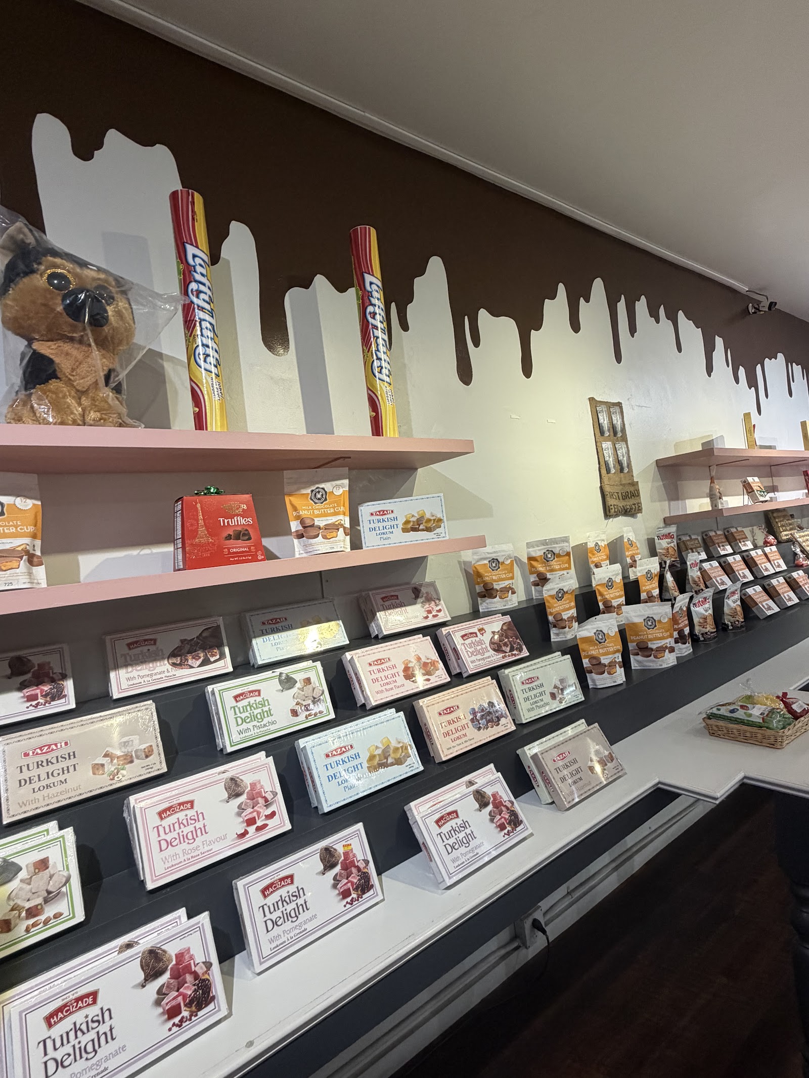 Owner-attributed confectionery display with Turkish delight boxes and chocolate-drip wall