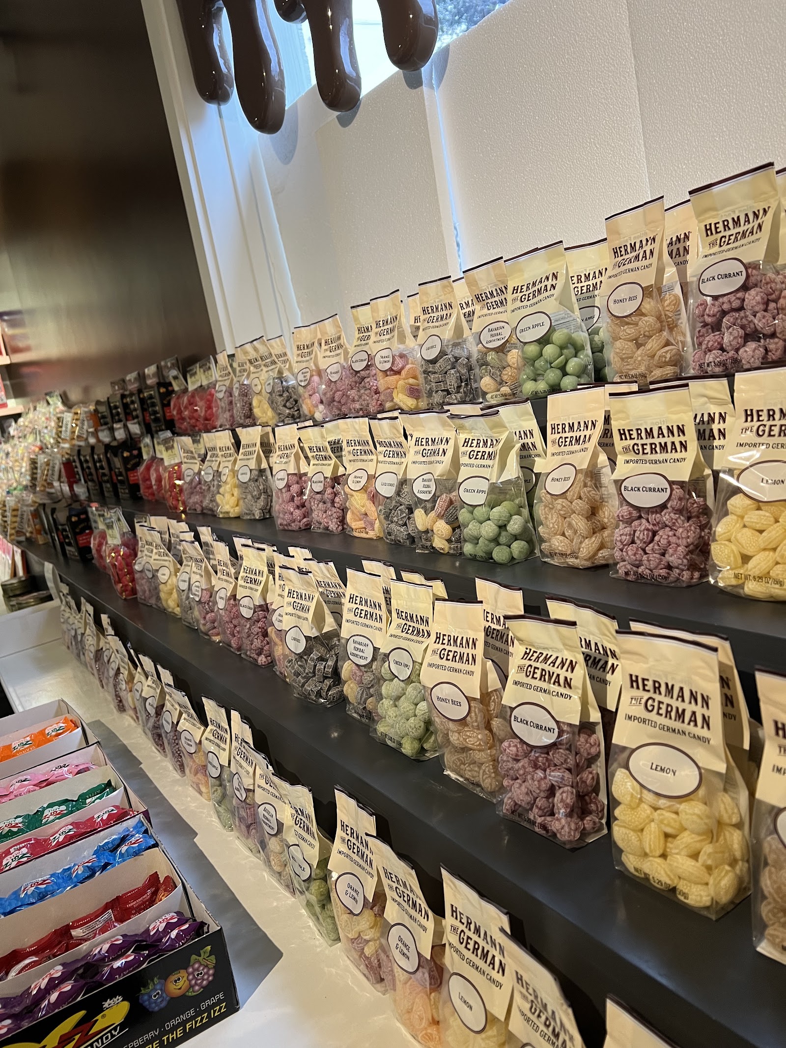 Rows of imported German candy bags on dark shelves